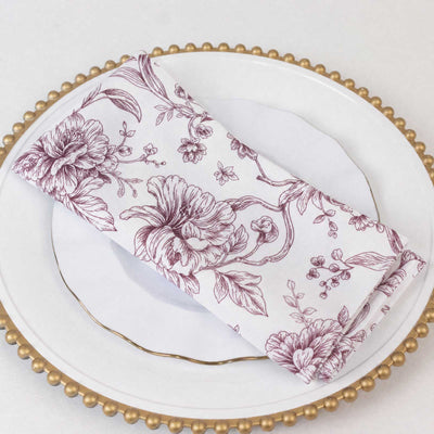 Floral cloth napkin on white plate with gold beaded charger
