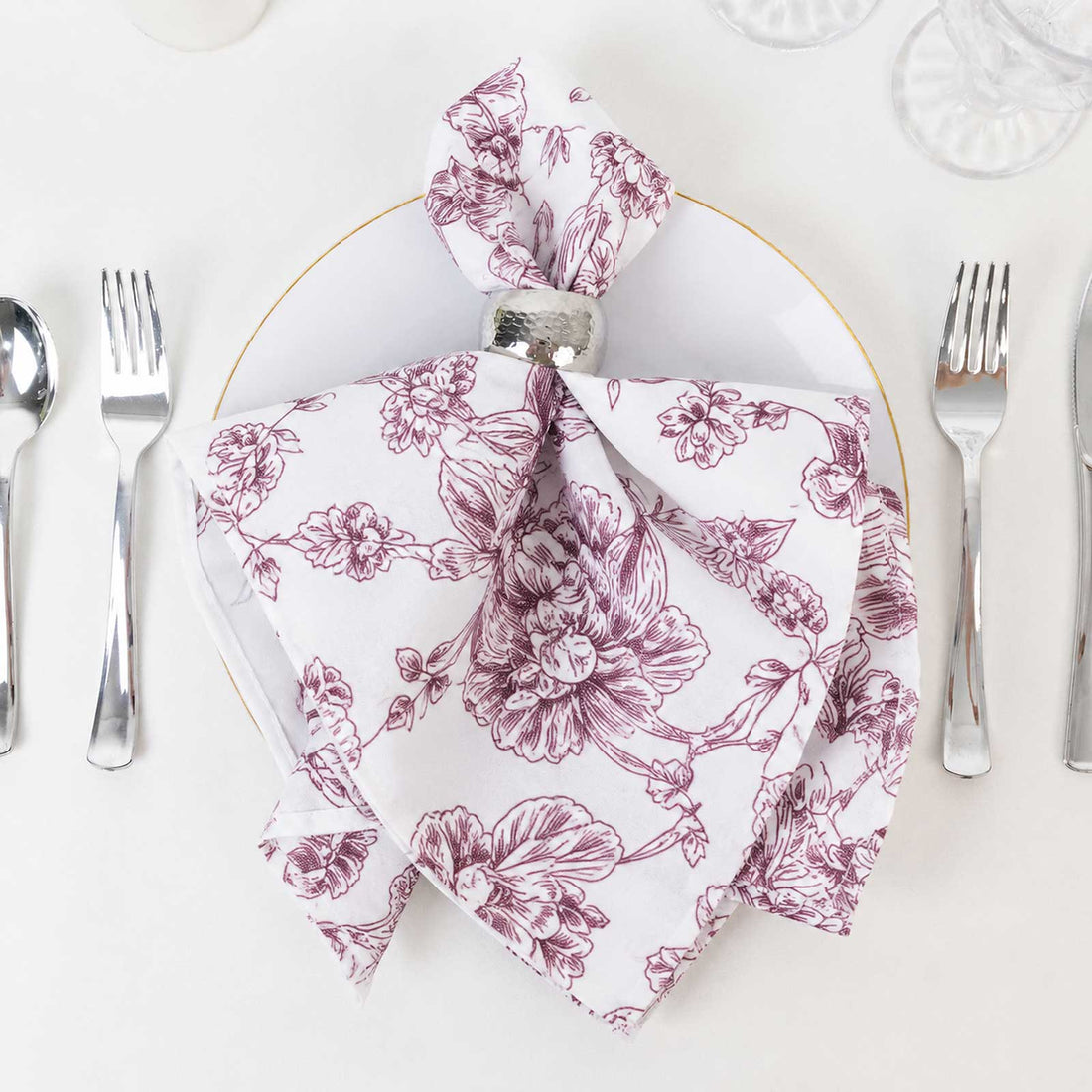 Floral printed folded napkin with silver ring on elegant table setting