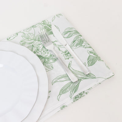 Floral tablecloth with white plate and silverware on a neutral background.