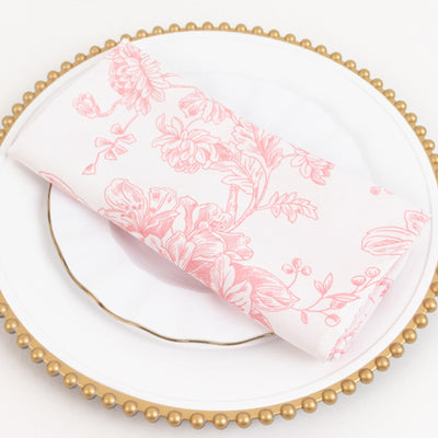 Pink floral napkin on a white plate with a gold rim.