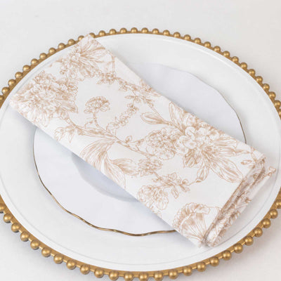 Elegant floral napkin on white plate with gold beaded charger plate