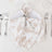 Elegant floral white napkin folded on a gold-rimmed plate with silverware
