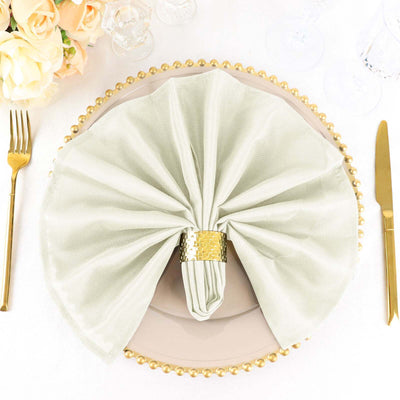 Elegant sage green napkin on a decorative plate with gold accents.