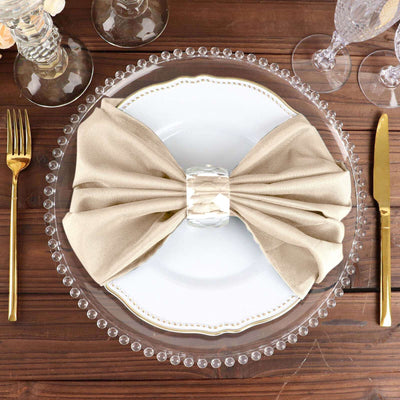 Elegant table setting with a stylish beige napkin bow on a white plate.