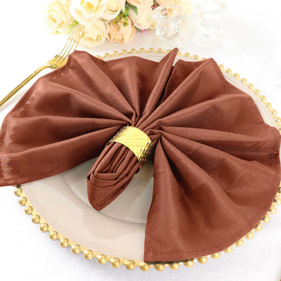 Elegant brown napkin elegantly folded on a decorative plate.