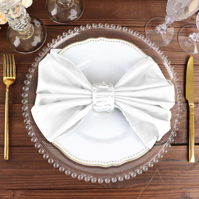 Elegant white napkin bow on a decorative plate with crystal accents.