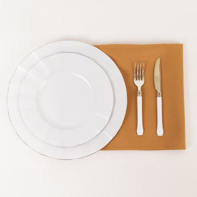 White dinner plates and silverware on a brown placemat