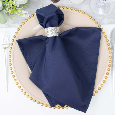 Navy napkin with silver napkin ring on decorative plate