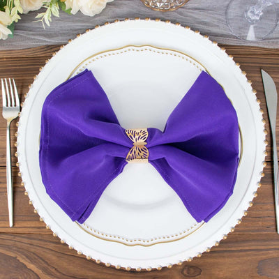 Purple napkin bow on an elegant dinner plate setting.