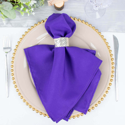 Purple napkin elegantly displayed on a plate with decorative beads.