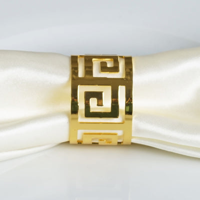 Gold Greek key napkin ring on a white satin napkin