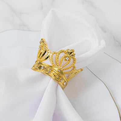 Gold crown napkin ring with rhinestones on a white napkin.