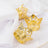Gold crown napkin rings on a white table setting.