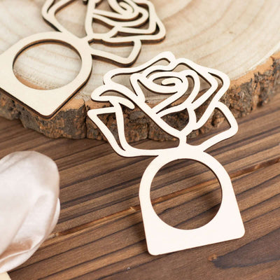 Wooden rose ring holder on a rustic wood background.