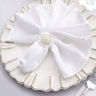 Elegant white napkin with decorative holder on a vintage plate.