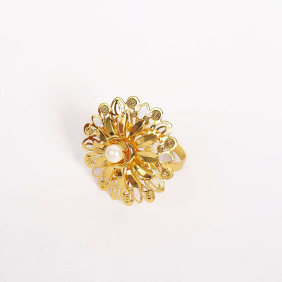Gold floral ring with pearl centerpiece on a plain background