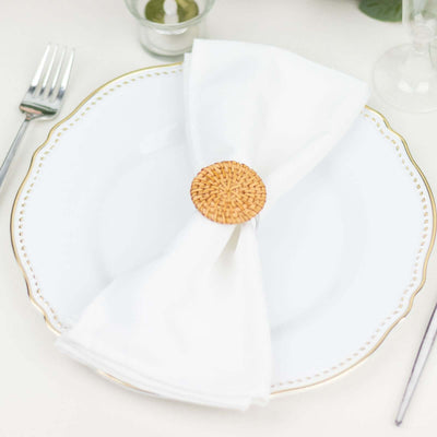 Elegant table setting with a white plate and woven napkin ring.