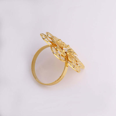 Gold butterfly ring with intricate design on a plain background