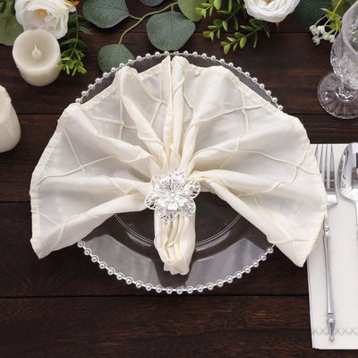 Elegant white napkin with decorative flower on a silver plate.