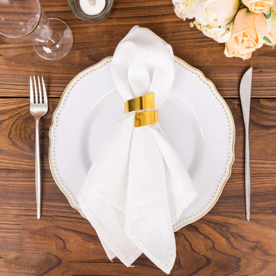 Elegant white napkin with gold ring on a decorative plate.