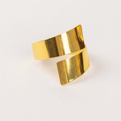 Gold twisted cuff bracelet on a plain background