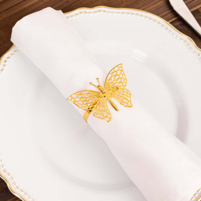 Gold butterfly napkin holder on a white napkin set on an elegant plate.