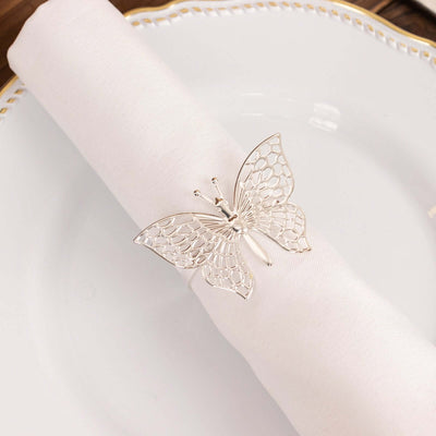 Silver butterfly napkin ring on a white napkin.