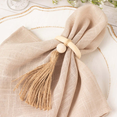 Natural linen napkin with wooden ring and tassel decoration.
