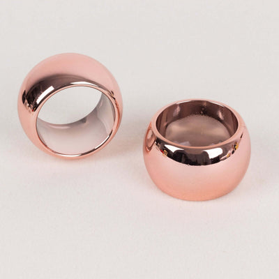 Rose gold circular rings on a light background.