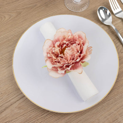 Elegant table setting with a flower-adorned napkin on a white plate.
