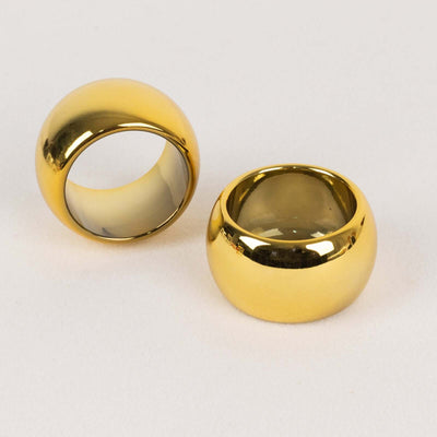 Two shiny gold rings on a light background.