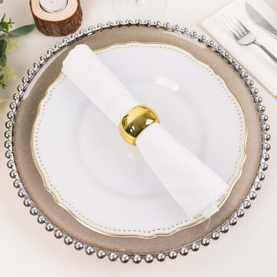 Elegant white plate with silver beaded rim and gold napkin ring.