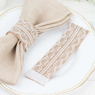 Beige linen napkin with lace trim and matching napkin ring on a decorative plate.
