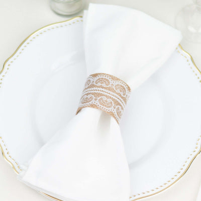 Elegant white napkin with lace ring on a decorative plate.