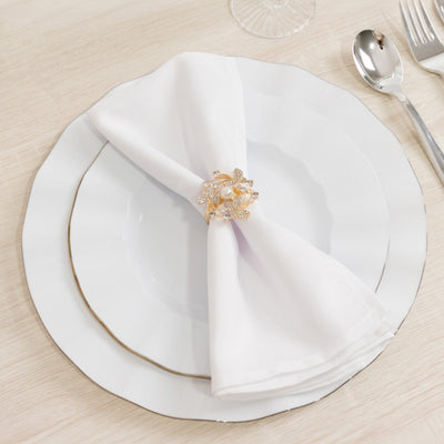 Elegant white plate with a folded napkin and decorative napkin ring.