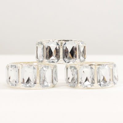 Three elegant crystal rings stacked together on a white background.