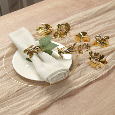 Elegant gold napkin rings with floral designs on a dining table setting.