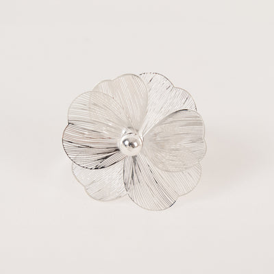 Silver flower brooch with intricate petal design and central pearl detail.