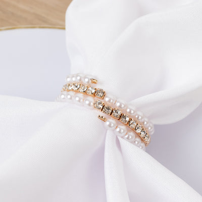 Pearl and crystal bracelet on a white fabric background.