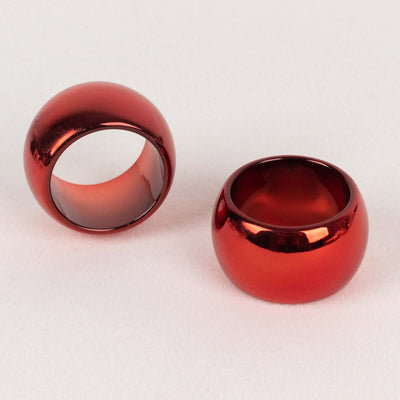 Shiny red statement rings on a plain background