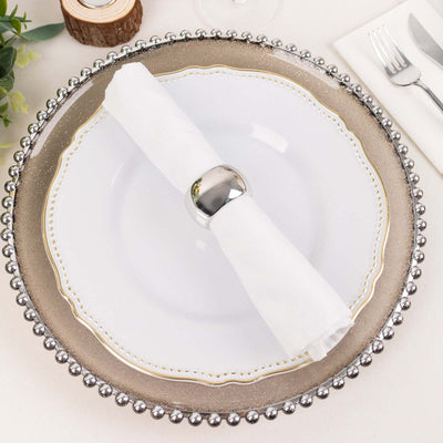 Elegant dinner plate with decorative rim and napkin holder on a table setting.