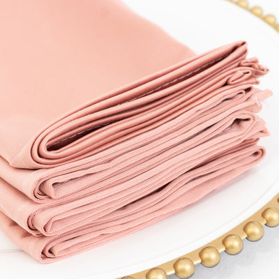 Stack of soft pink fabric napkins on a decorative plate.