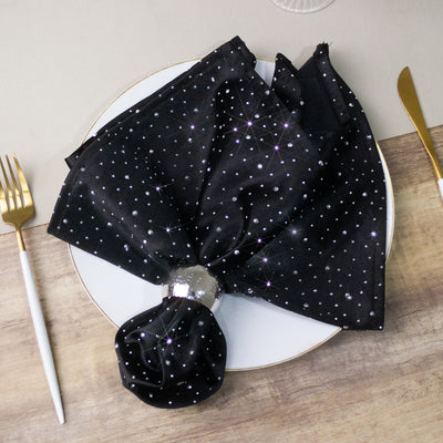 Black starry napkin elegantly styled on a white plate with gold cutlery.