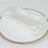 White napkins with sparkling embellishments on a decorative plate.