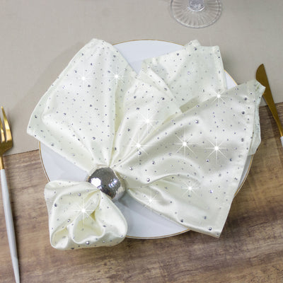Elegant white napkin with sparkling embellishments on a plate.