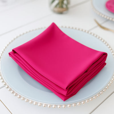 Stack of vibrant pink napkins on a blue plate.
