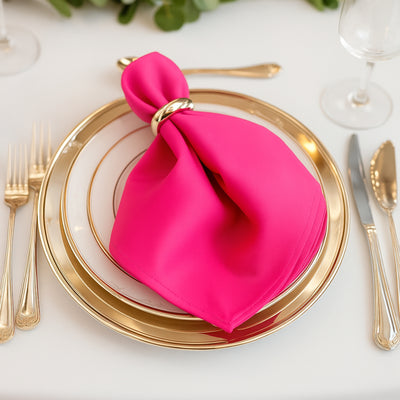 Pink napkin elegantly styled on a gold plate setting.