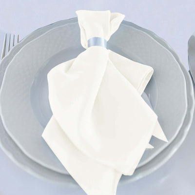 Elegant white napkin tied with a blue ribbon on a grey plate.