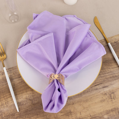 Lavender napkin elegantly arranged on a dinner plate with a gold napkin ring.