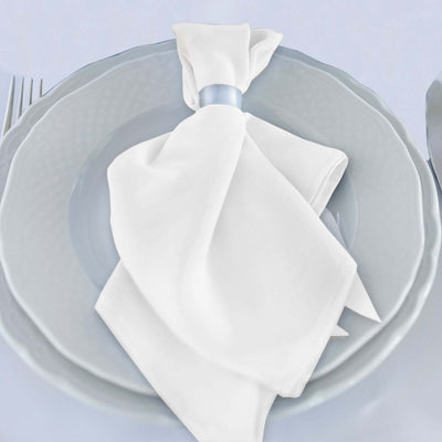 Elegant white napkin tied with a ribbon on a gray plate.